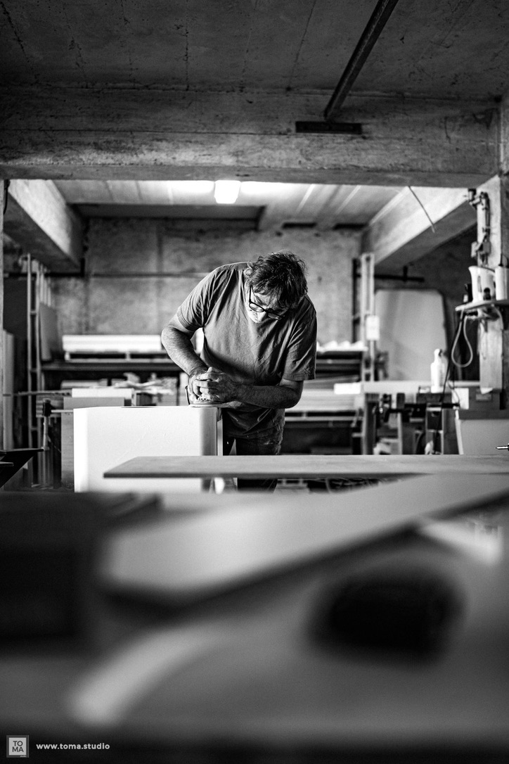travail de finition sur un meuble dans l'atelier Angebault ébénisterie